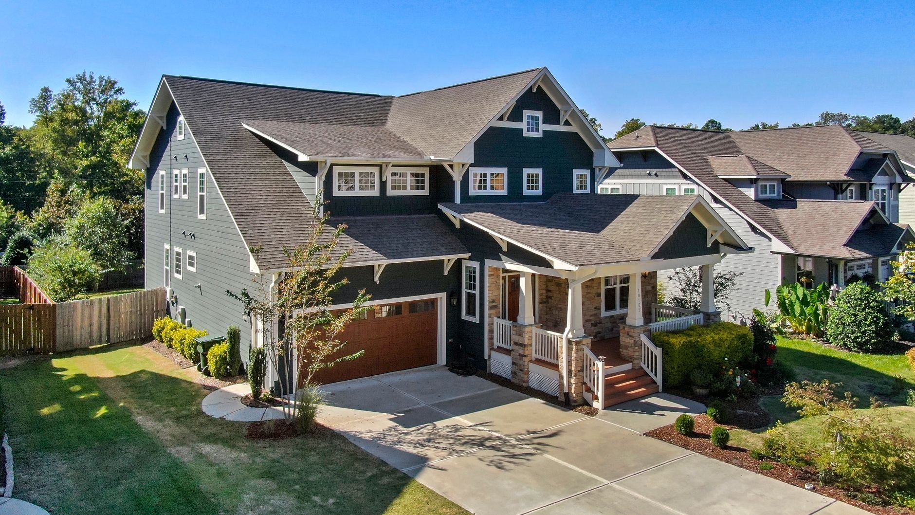 A beautiful Craftsman-style house with a spacious porch and manicured lawn