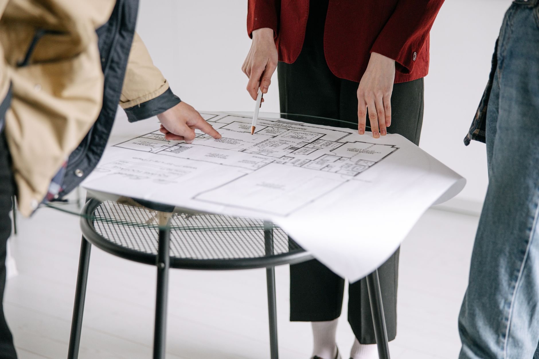 Architect reviewing home plans with a client couple at a table